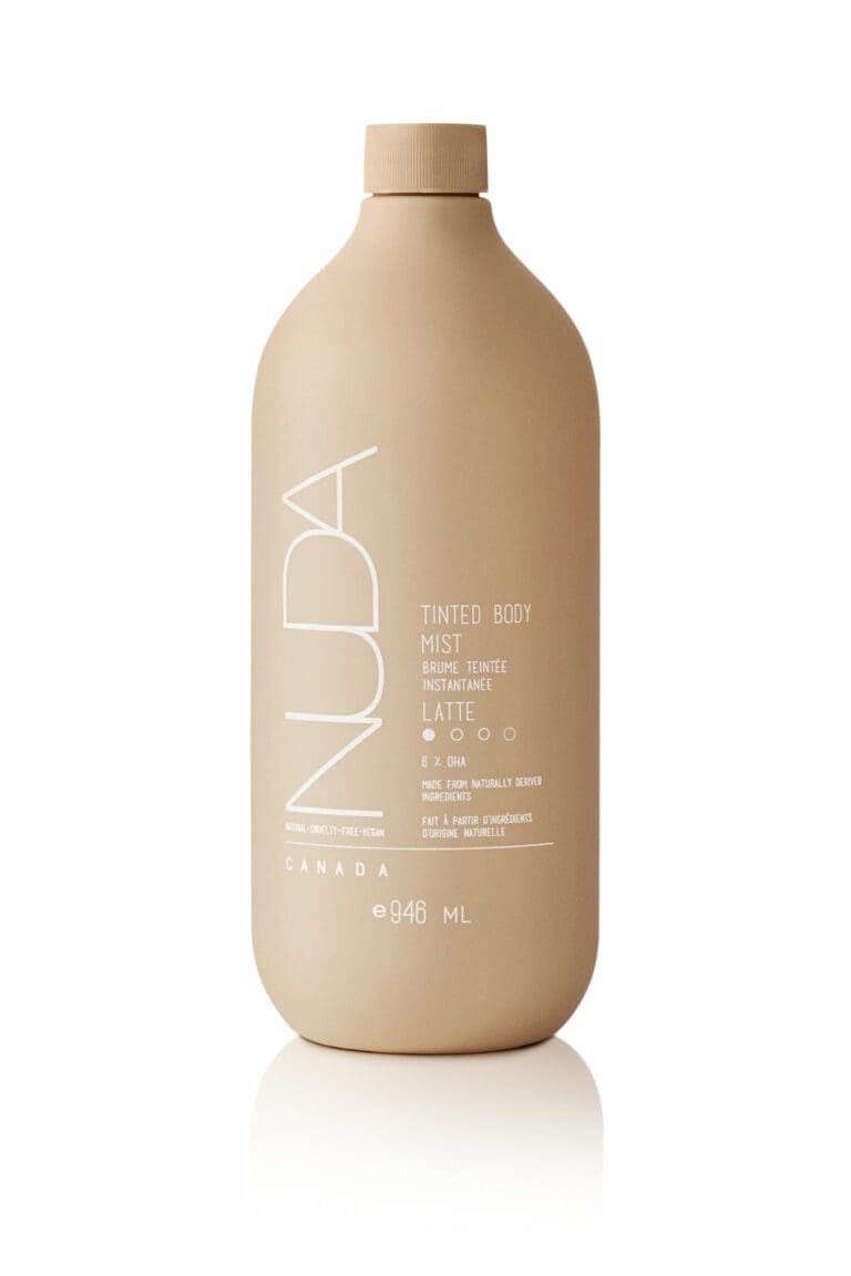 Edgemont A sleek, brown bottle labeled "nuda tinted body mist" in minimalist typography, emphasizing its qualities such as "oat milk latte" and "small batch" from canada, displayed against a white background. North Vancouver